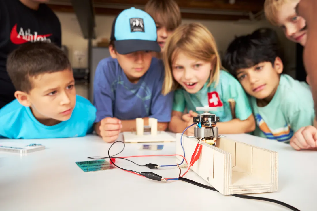 Eine Gruppe Kinder staunt über ein Experiment