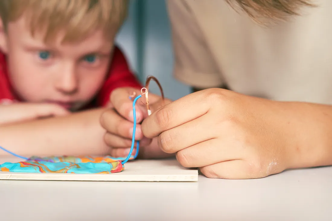 Ein Kind staunt über sein selbst gebautes Projekt
