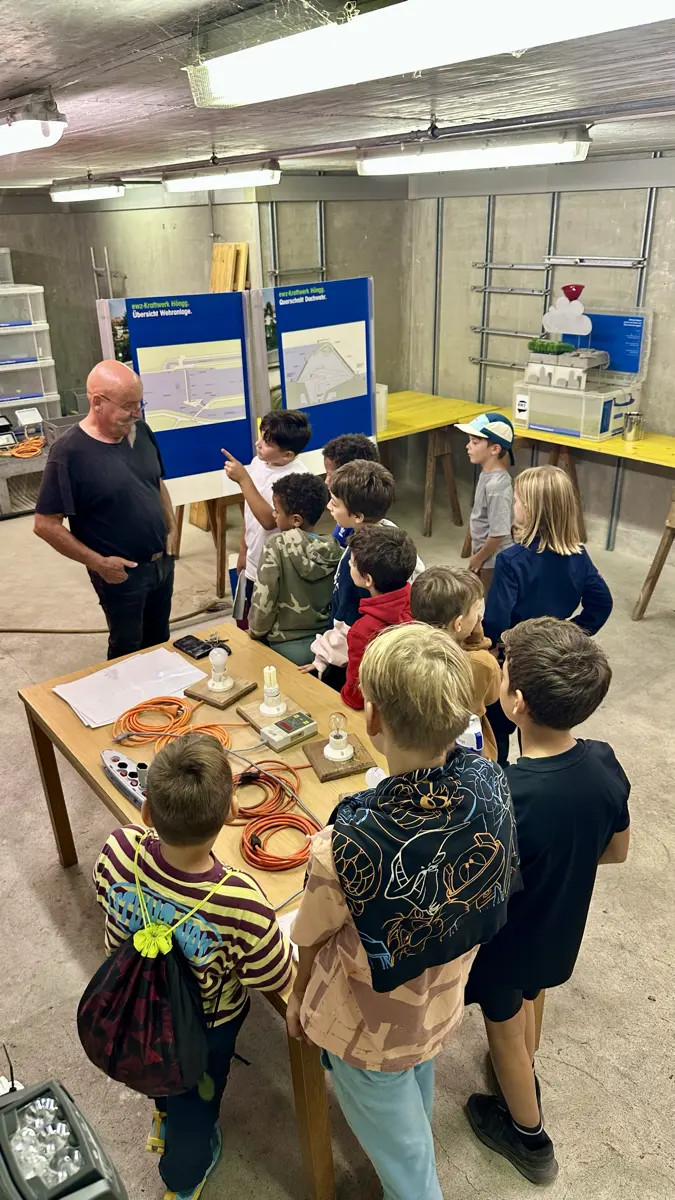 Die Gruppe beim Ausflug um einen Tisch mit Experimenten versammelt