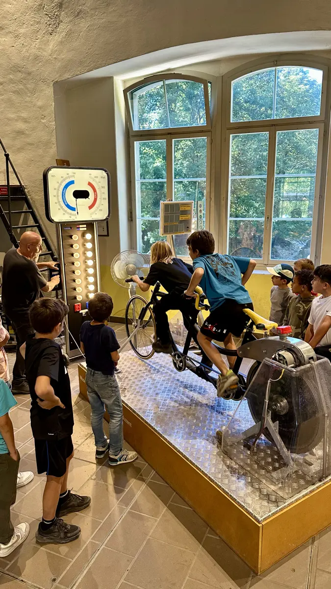 Ein Kind erzeugt auf dem Velo-Generator Strom für eine Lampe
