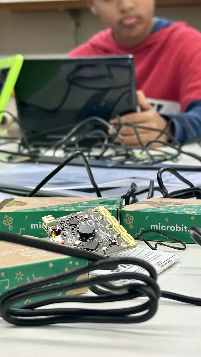 Ein Kind programmiert am Laptop einen micro:bit